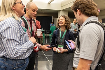 A gathering of four attendees engaged in conversation and laughter, capturing the essence of connection and enjoyment at an event.